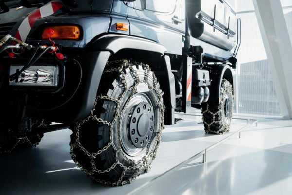 Jeep with snow chains parked indoors at the white tile on vehicle show free photo